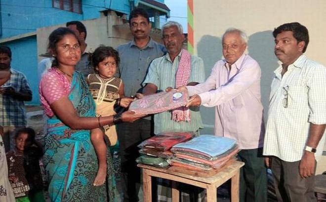 Real needs: Hamali maistry Lakshminarayana distributes clothes to residents of Kuppam.